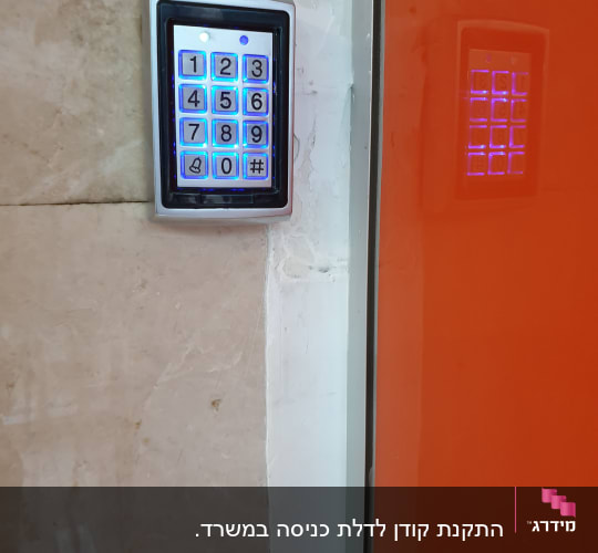 לוח מקשים מואר עם מספרים ליד דלת כתומה